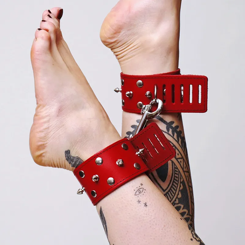 Lederfesseln mit Nieten und rotem Karabiner